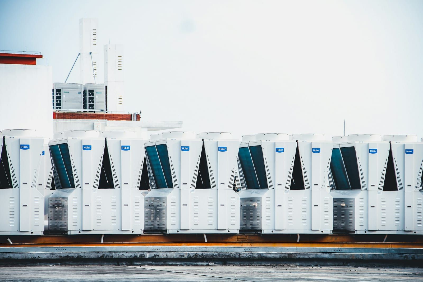 A row of condenser units on a flat commercial roof