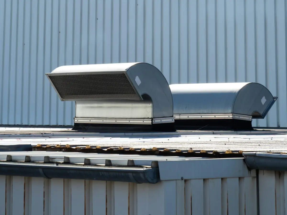 Two metal rooftop units sitting on a commercial roof